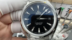 Held in a gloved hand from the front, black dial and date at 3