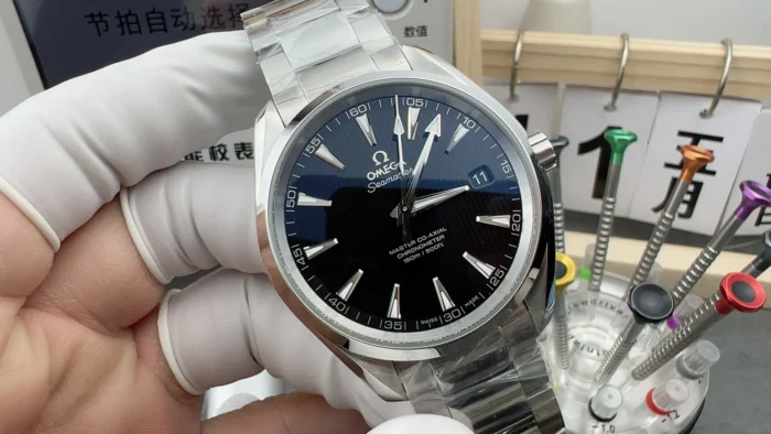 Omega Aqua Terra 231.10.39.21.01.002 in a gloved hand on the workbench