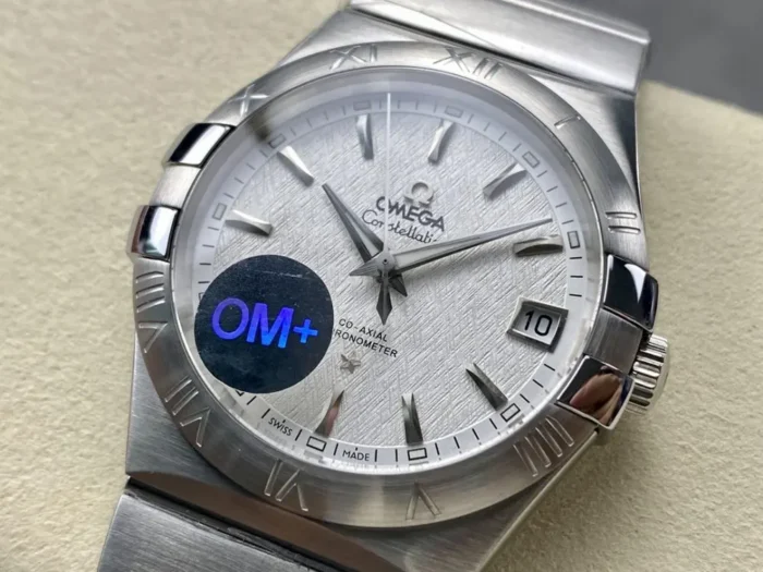 White textured dial from the left with a protective sticker on the glass