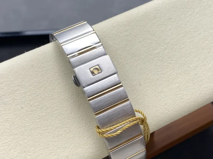 Silver and yellow gold tone bracelet on edge with a gold cord hang tag on the clasp