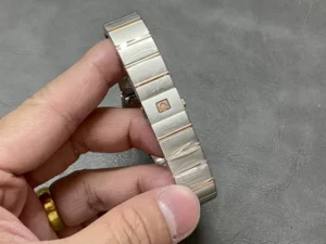 Bracelet of the 25mm rose gold tone model on edge, Omega plate on the clasp
