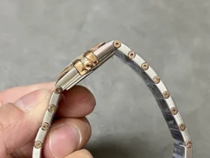 Two-tone rose gold tone bracelet curled into a loop, case side and clasp in view