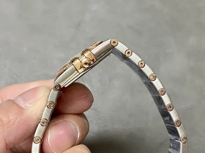 Two-tone rose gold tone bracelet curled into a loop, case side and clasp in view