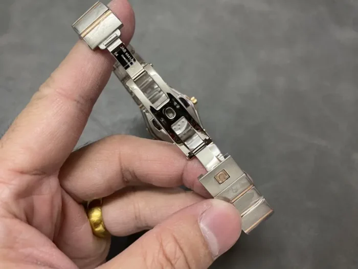 Folding clasp of the two-tone rose gold tone bracelet opened in hand
