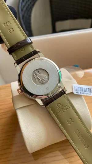 Solid caseback with a seahorse medallion, olive strap lining stamped Omega