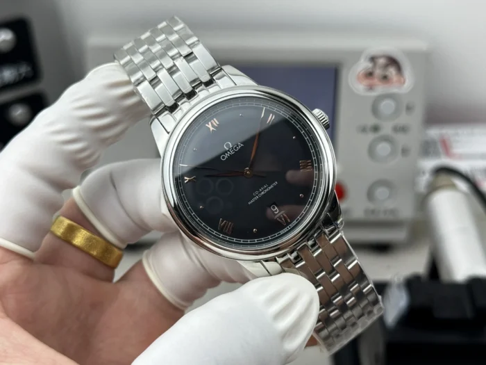 Black dial straight on with the bracelet held up behind
