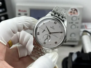 Silver grey dial in hand, bracelet held up behind it