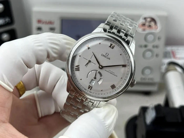 Silver grey dial in hand, bracelet held up behind it