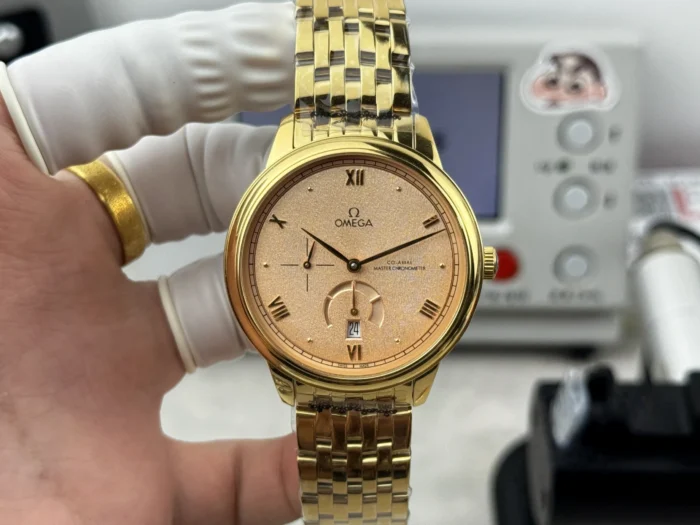 Held in a glove, salmon grained dial and gold tone bracelet