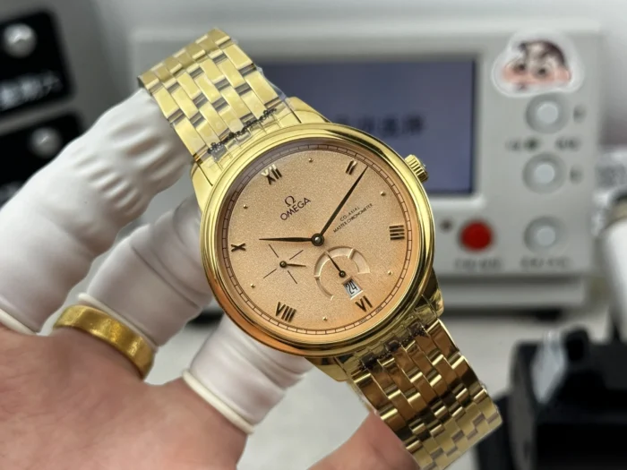 Salmon dial facing forward, gold tone bracelet raised behind