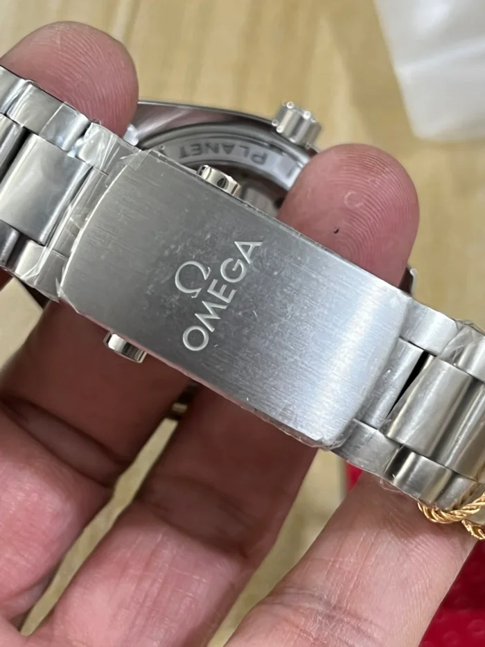 Clasp cover with OMEGA engraving held in hand