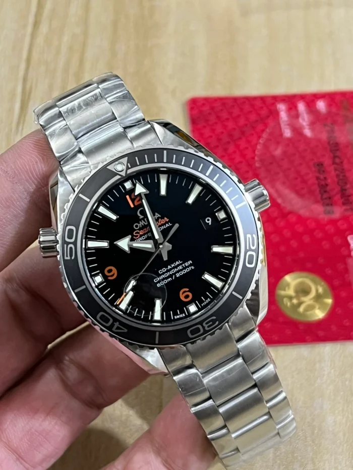 Dial at an angle in hand, orange numerals