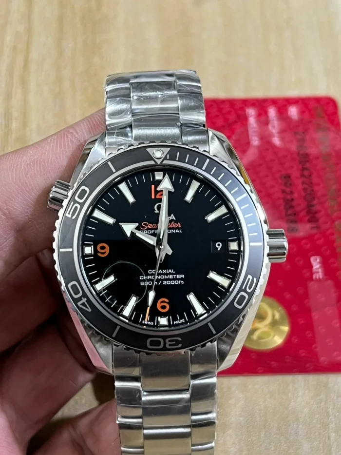 Held in hand over a red card, black bezel and dial
