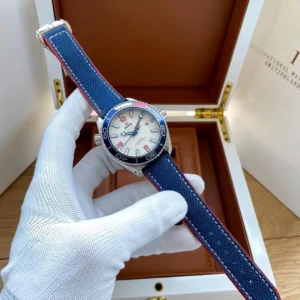 Held in a gloved hand above an open wooden box