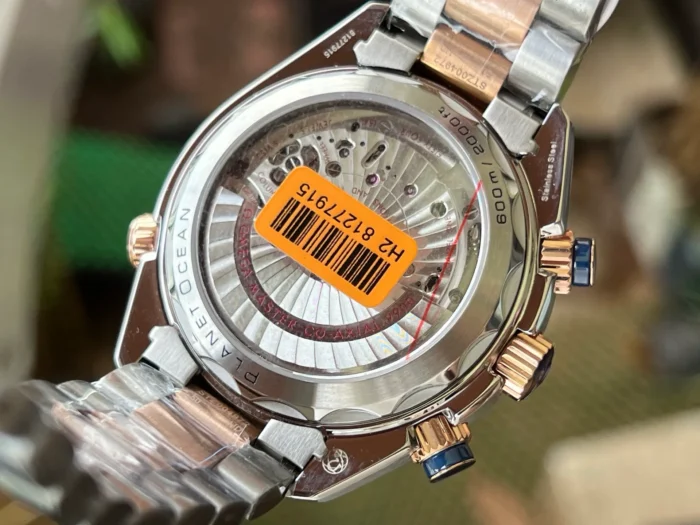 Display caseback with an orange barcode sticker, two tone Planet Ocean chronograph