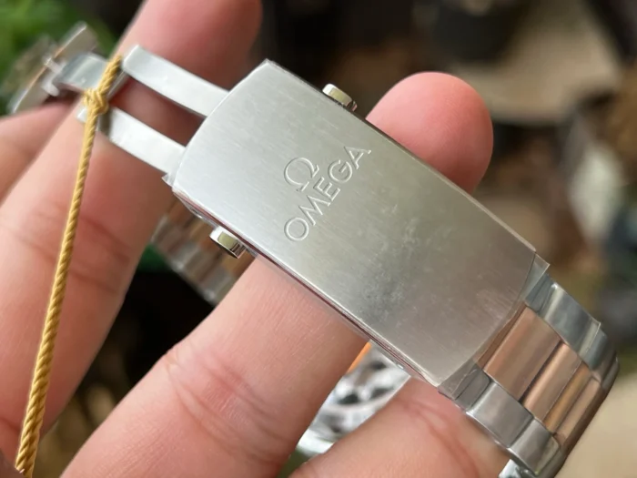 Clasp with OMEGA engraving and a gold tone tag thread
