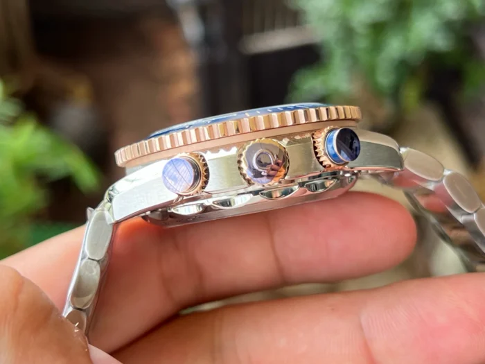 Side view of the crown and blue pushers with rose gold tone collars