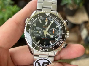 Held in hand from the front, black bezel and dial