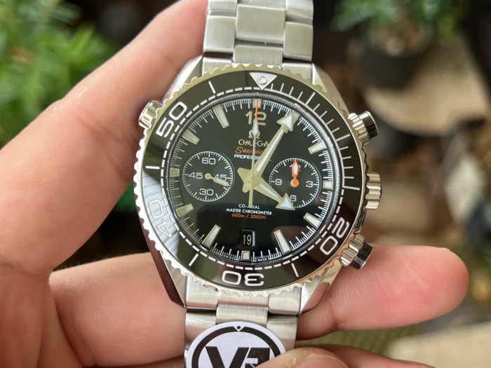 Held in hand from the front, black bezel and dial
