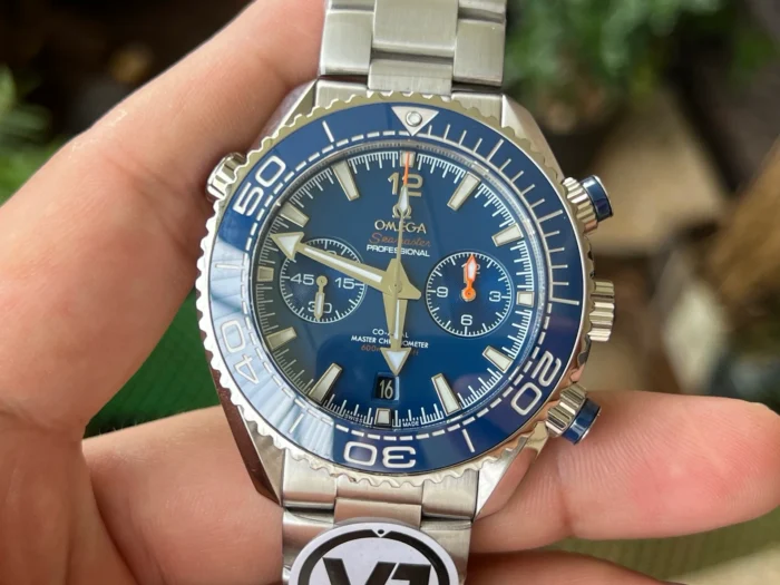 Blue chronograph dial in hand, plants in the background