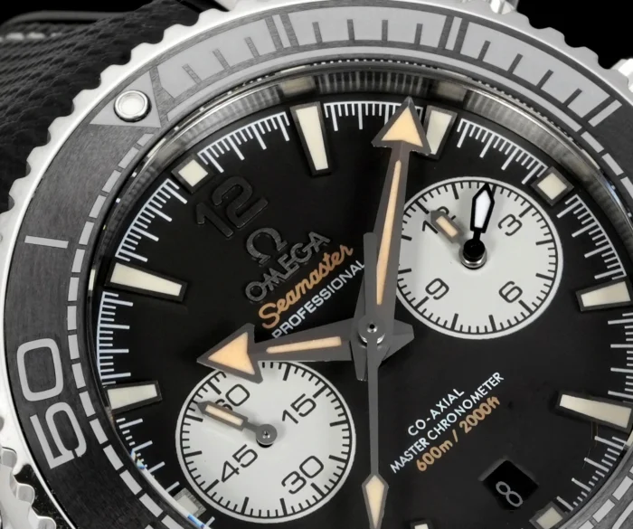 Macro of the dial: white subdials and orange Seamaster script