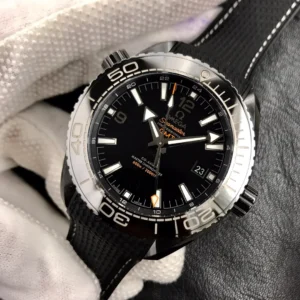 Black GMT dial at an angle in a gloved hand, orange-accent Deep Black GMT