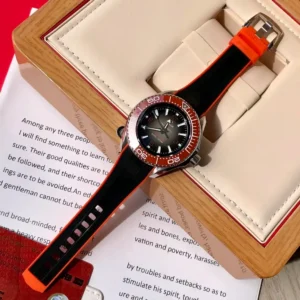 Watch in an open box beside a printed booklet