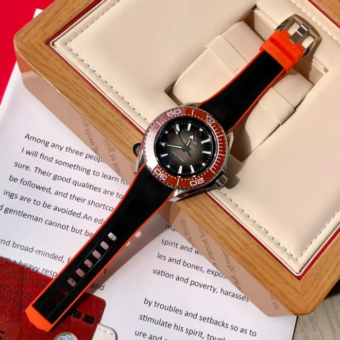 Watch in an open box beside a printed booklet