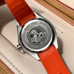 Solid caseback with the seahorse emblem, orange strap underside