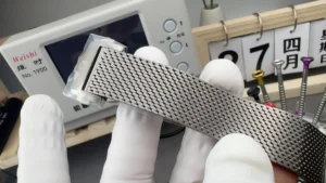 Mesh bracelet held flat, clasp end in protective film