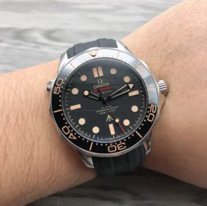On the wrist, black dial with tan markers and black rubber strap
