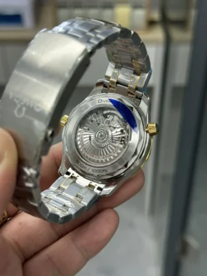 Clear caseback in hand with the two tone bracelet folded