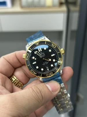Black wave dial in hand, yellow gold tone bezel ring and crown