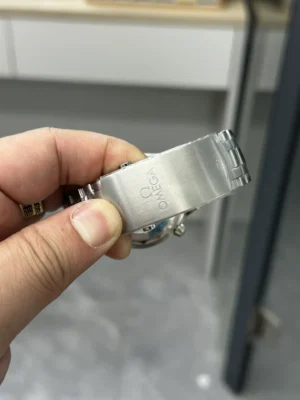 Brushed clasp with the Omega logo, close to the lens