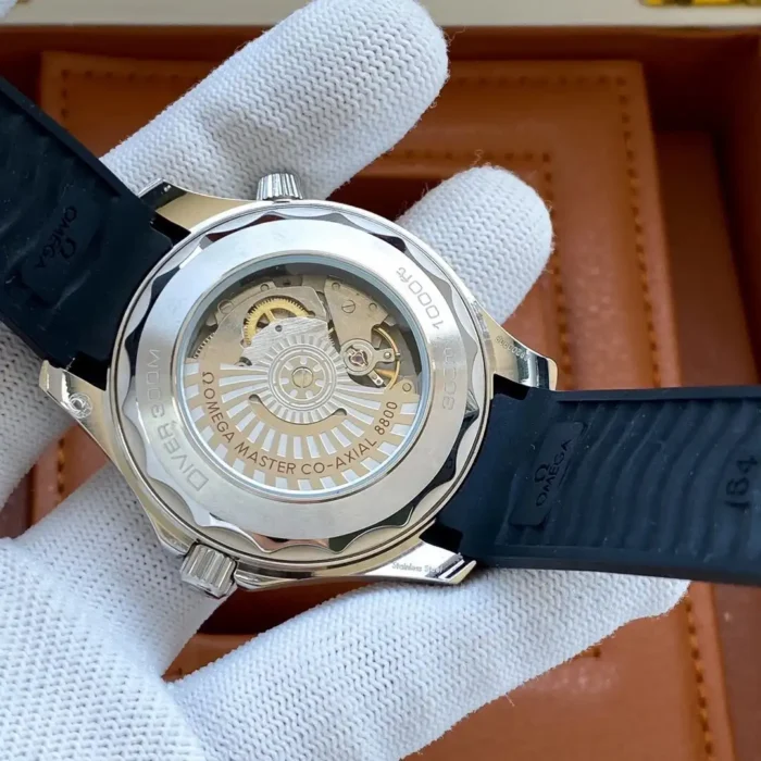 Clear caseback in a white glove over a wooden box