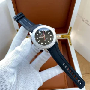 Watch on a black rubber strap held over a wooden box