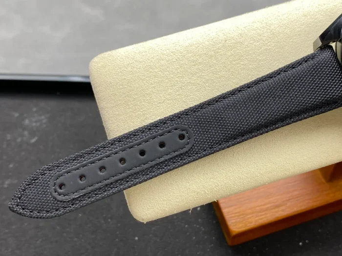 Tail of the black fabric strap with its row of holes