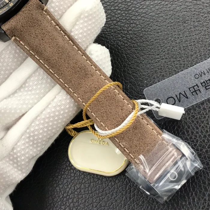 Brown strap with the buckle in protective film and a cream Omega tag