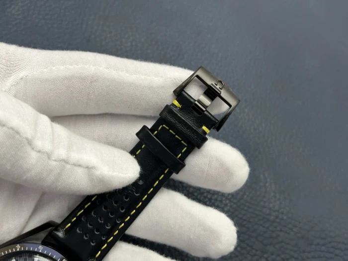 Black pin buckle on the perforated strap with yellow stitching