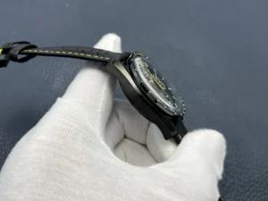 Left flank of the black case held between gloved fingers