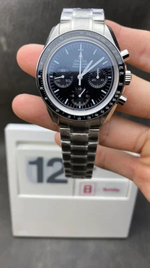 Held in hand in front of a desk calendar, black dial and bracelet