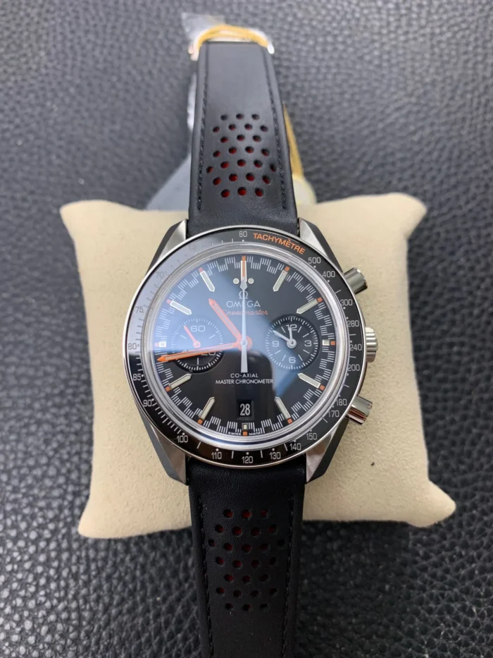 Front view on a cushion, orange hands on the black dial