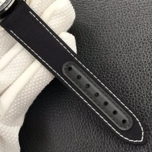 Tail of the black fabric strap with white stitching