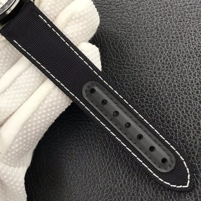 Tail of the black fabric strap with white stitching