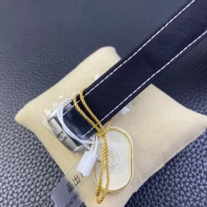 Fabric strap and buckle with the tag on its gold cord